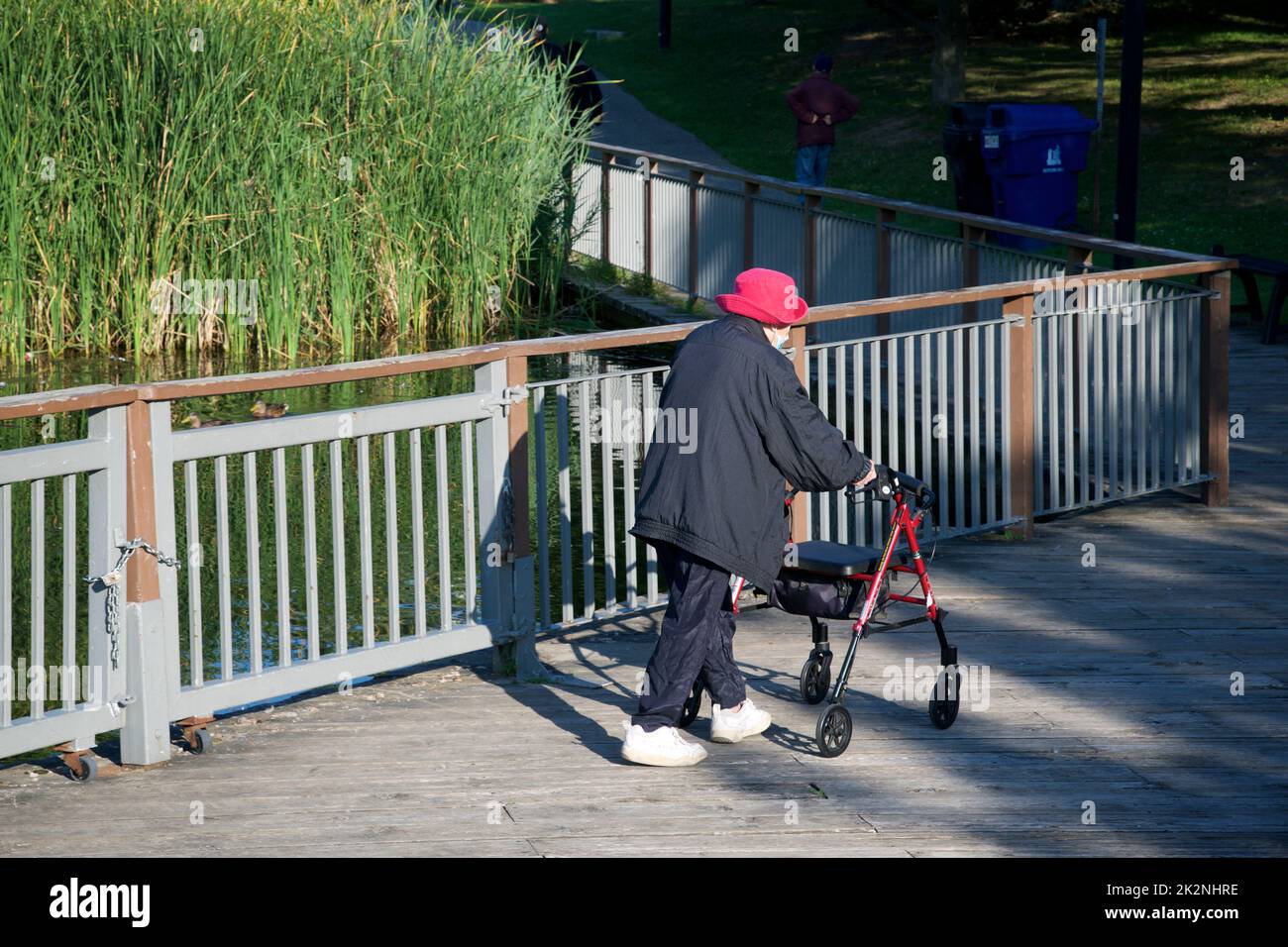Toronto, Ontario / Canada - 09/03/2022: Una donna anziana che cammina nel parco pubblico con un camminatore su ruote Foto Stock