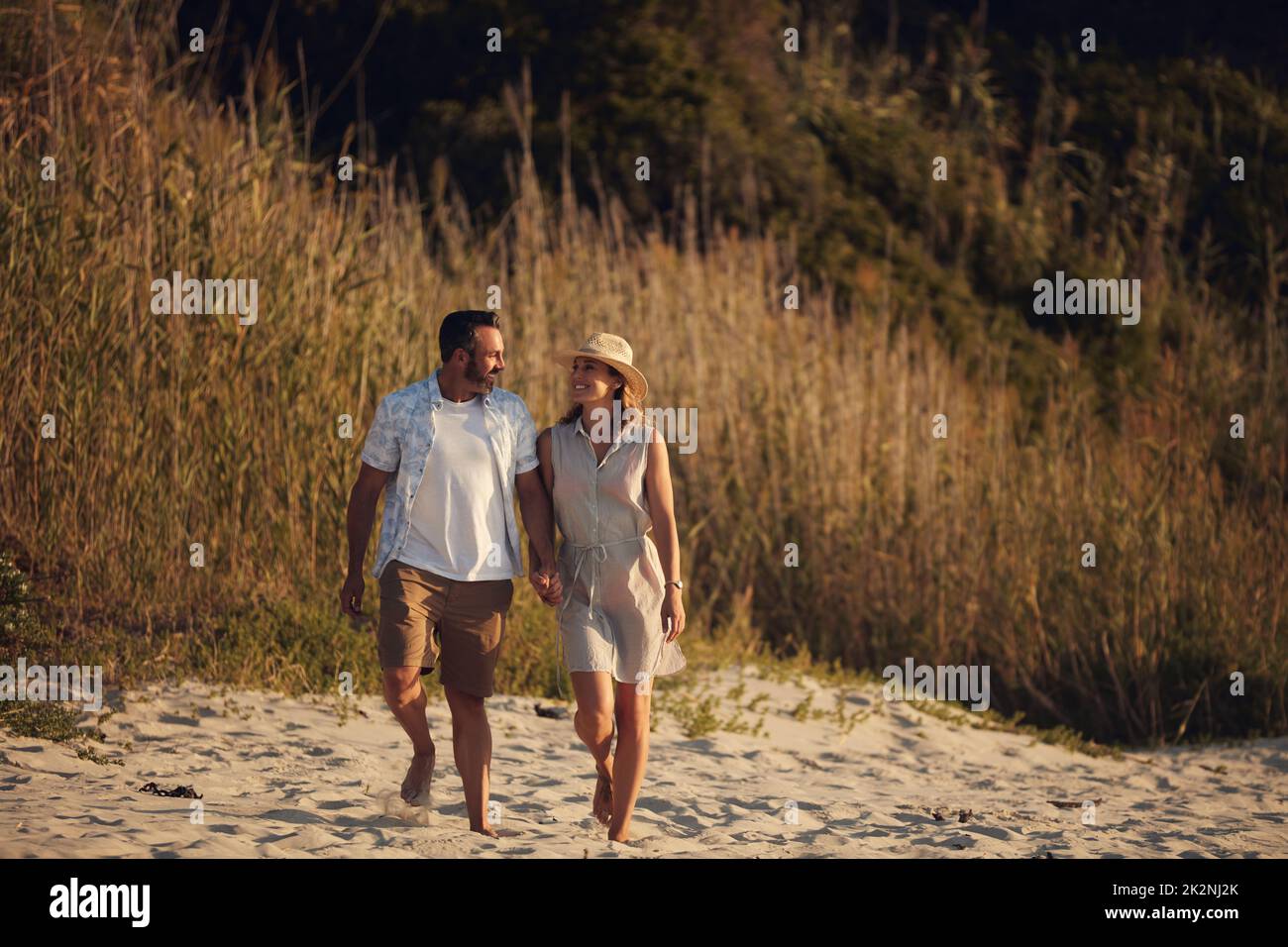 La spiaggia è dove le favole accadono. Scatto di una coppia matura affettuosa facendo una passeggiata sulla spiaggia. Foto Stock