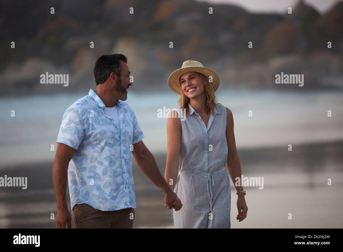 Sei pronto per la tua sorpresa. Scatto di una coppia matura affettuosa facendo una passeggiata sulla spiaggia. Foto Stock