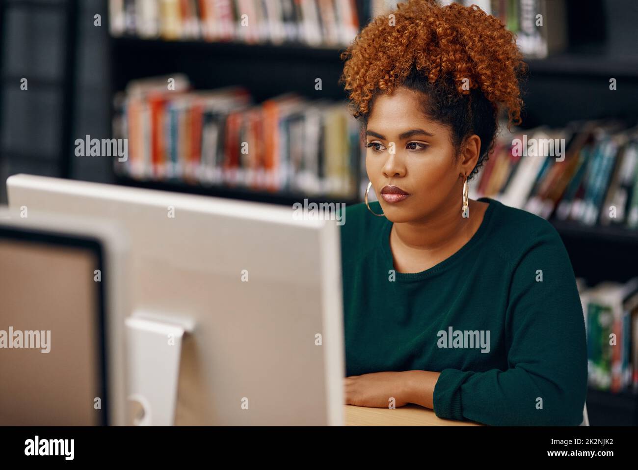 Preparazione per gli esami finali. Scatto ad alto angolo di una giovane studentessa universitaria che studia in biblioteca. Foto Stock