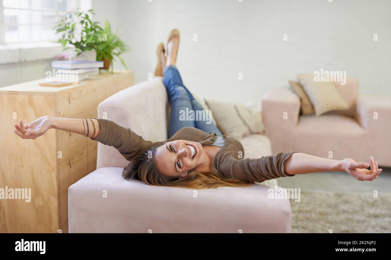 Ora locale = tempo libero. Ritratto corto di una donna attraente rilassante sul divano a casa. Foto Stock