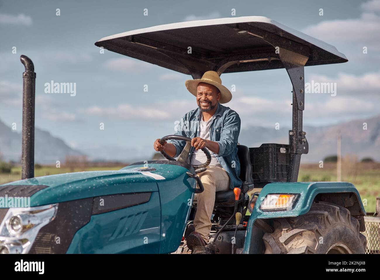 Fuori ai campi andiamo. Colpo di un uomo maturo che guida un trattore in un'azienda agricola. Foto Stock