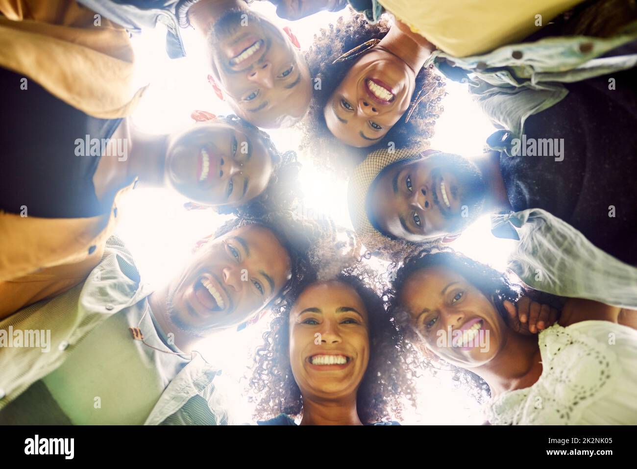 Circondatevi di persone che vi accompagnano. Scatto ritagliato di un gruppo di amici che guarda verso il basso la fotocamera. Foto Stock