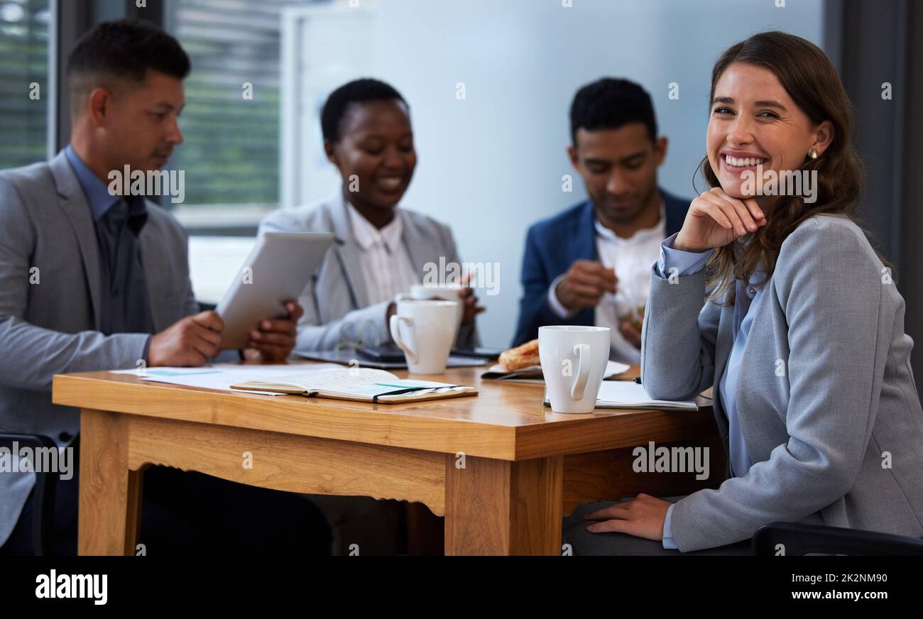 Impegno individuale per uno sforzo di gruppo. Foto di un gruppo di colleghi che hanno una riunione e la colazione in un ufficio moderno. Foto Stock