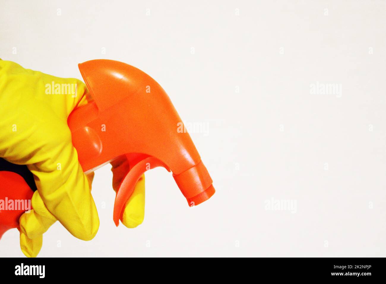 Immagine di una mano che indossa un guanto di gomma con uno spray detergente. Il concetto di purezza. Foto Stock