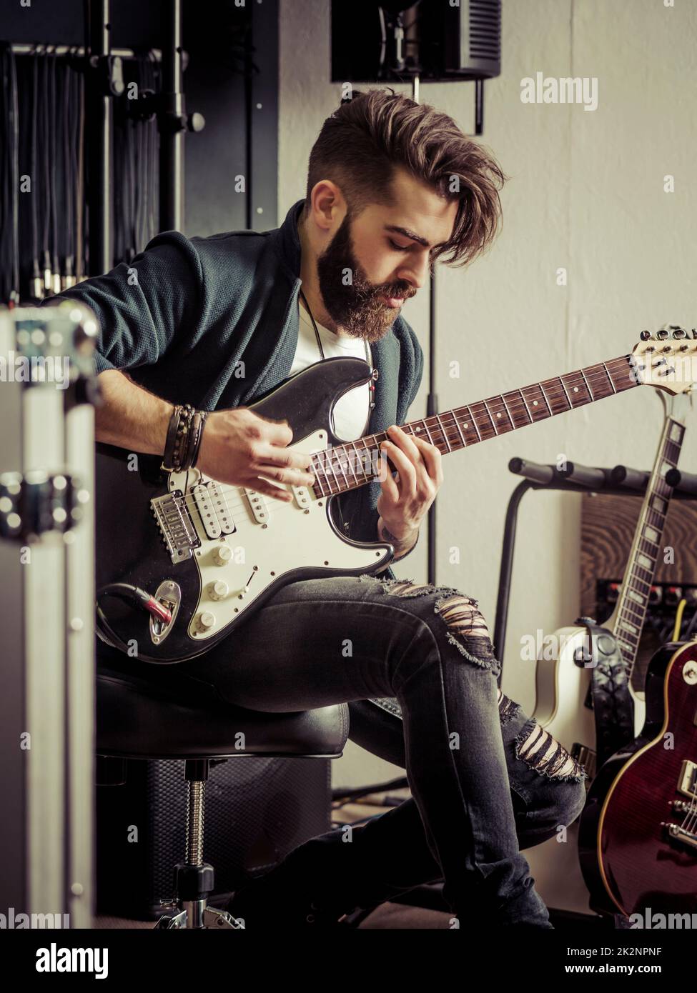 Suonare la sua chitarra elettrica nello studio di registrazione Foto Stock