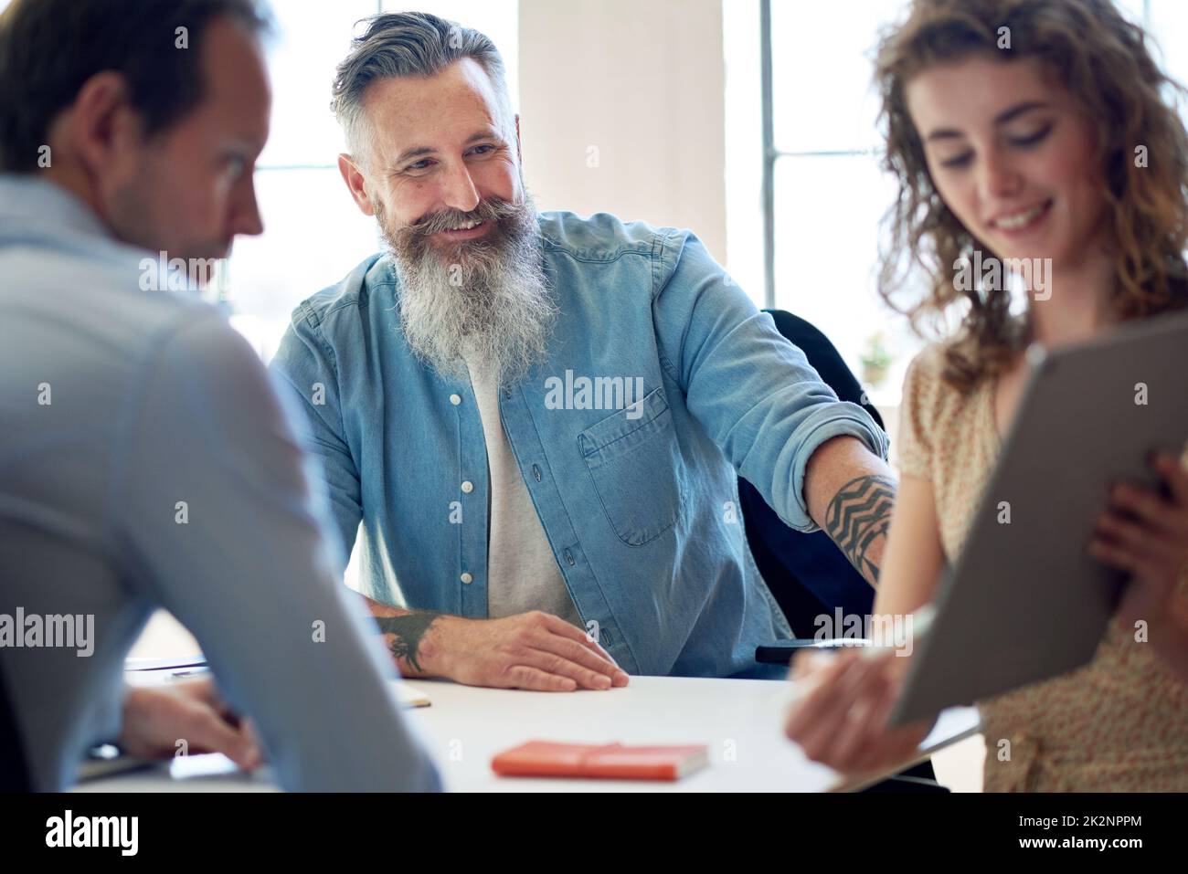 il leader del team di imprenditori incontra i colleghi in ufficio con una donna che utilizza un tablet e presenta idee per lo sviluppo aziendale Foto Stock
