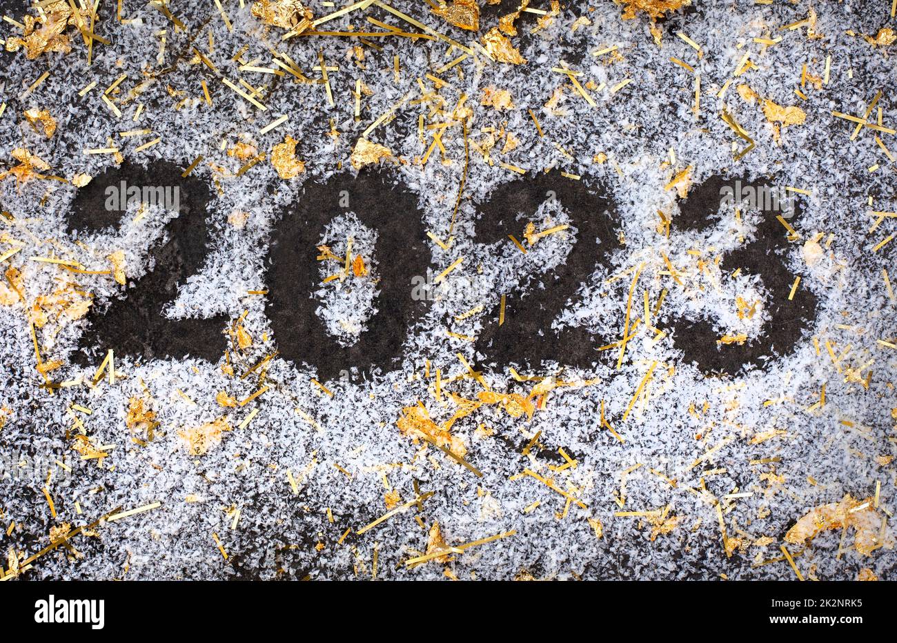 2023 su sfondo scuro con neve e scintille dorate, nuovo anno, nuovo inizio Foto Stock