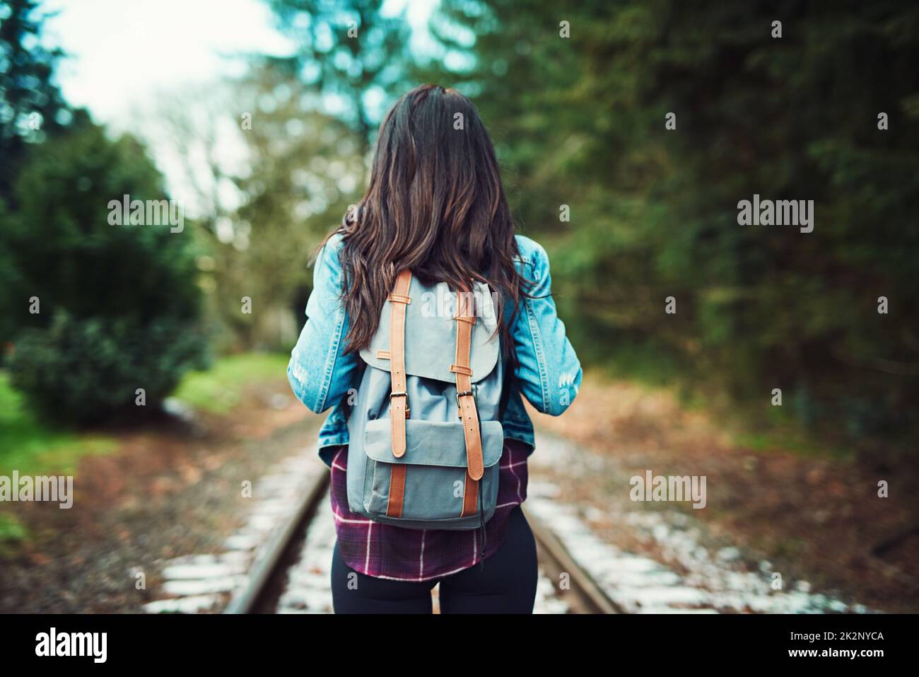 La natura è dove ama domandarsi. Ripresa da una donna irriconoscibile che cammina sui binari del treno all'aperto. Foto Stock