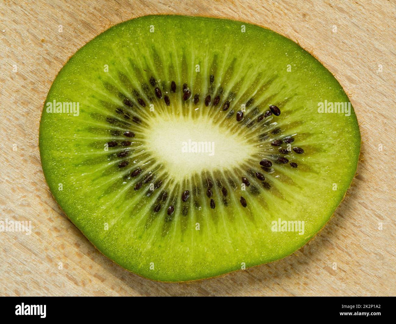 Fetta di frutta kiwi su sfondo di legno Foto Stock