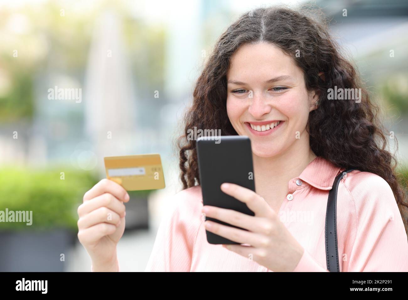 Donna felice che acquista on line con carta di credito e telefono cellulare Foto Stock