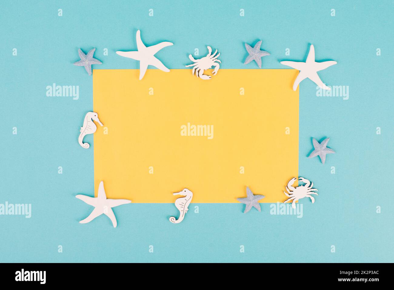 Carta vuota di colore giallo, stelle marine, cavallucci marini e granchio che proiettano una cornice, vacanze estive, destinazione turistica di viaggio, copia spazio per il testo Foto Stock