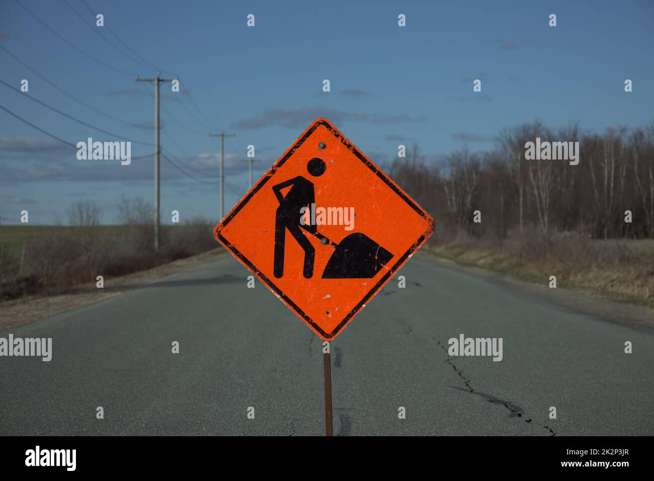 segnaletica stradale arancione da costruzione sulle nuvole di strade rurali e sulla linea elettrica Foto Stock