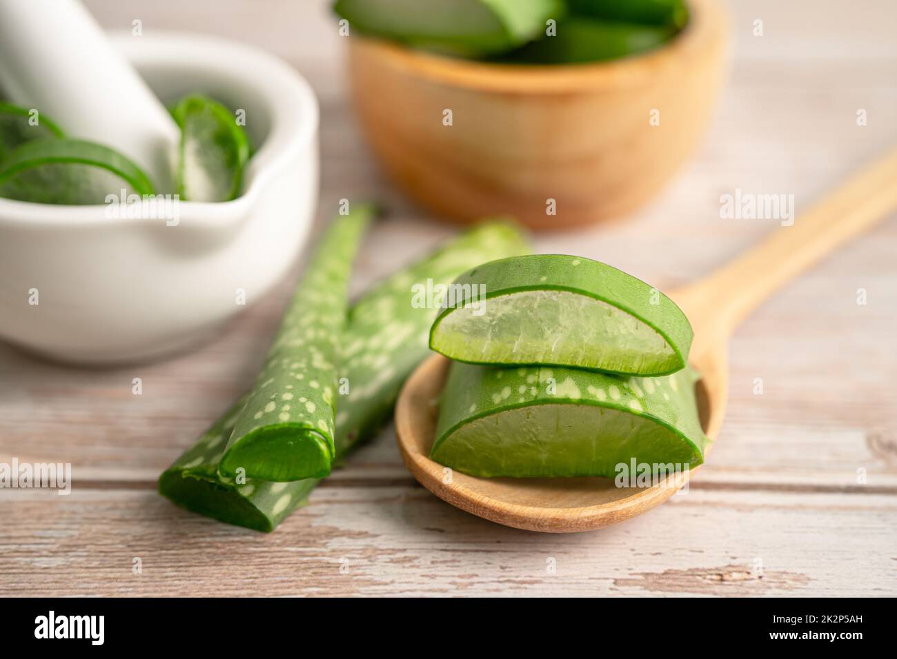 Aloe vera con fette su sfondo di legno, pianta medicinale per la salute e la bellezza. Foto Stock