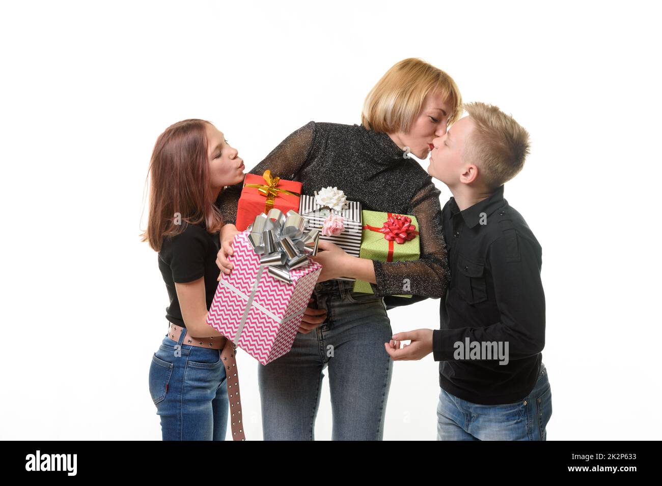 I bambini si sono congratulati con la mamma per il suo compleanno e hanno dato regali, la mamma bacia suo figlio come segno di gratitudine Foto Stock