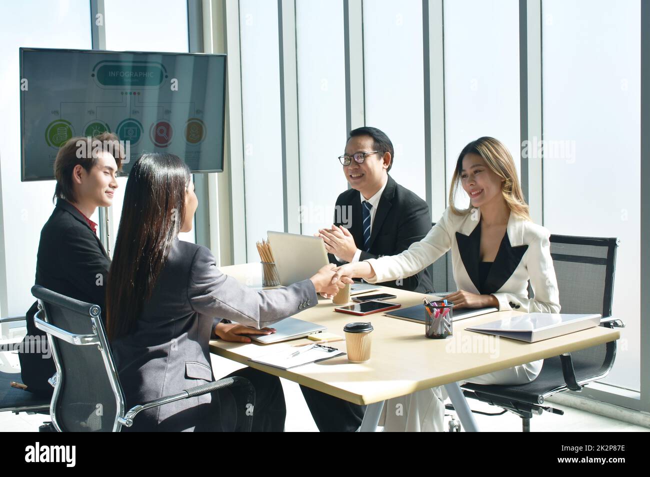 Le donne asiatiche di affari che scuotono la mano insieme dopo la riunione con successo e vincere l'affare nella stanza dell'ufficio Foto Stock