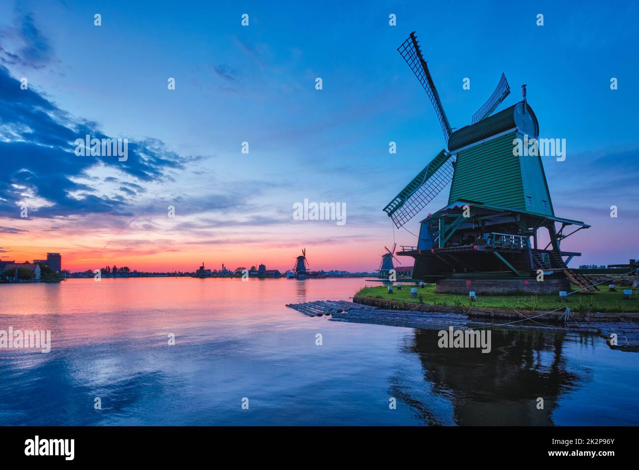 Mulini a vento nel famoso sito turistico Zaanse Schans in Olanda con cielo drammatico. Zaandam, Paesi Bassi Foto Stock