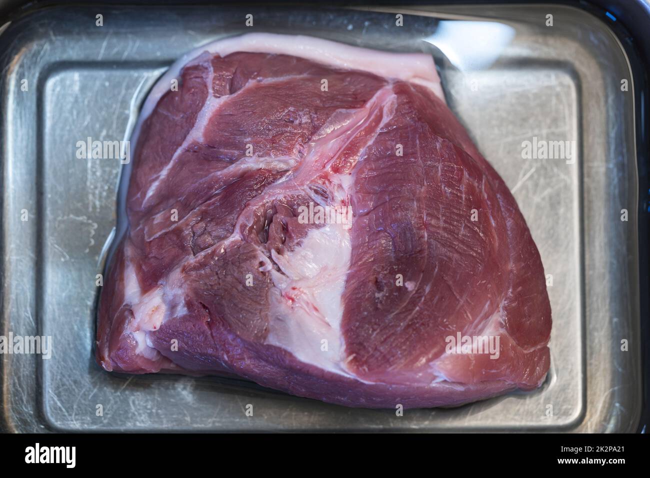 spalla di maiale crudo in una casseruola Foto Stock