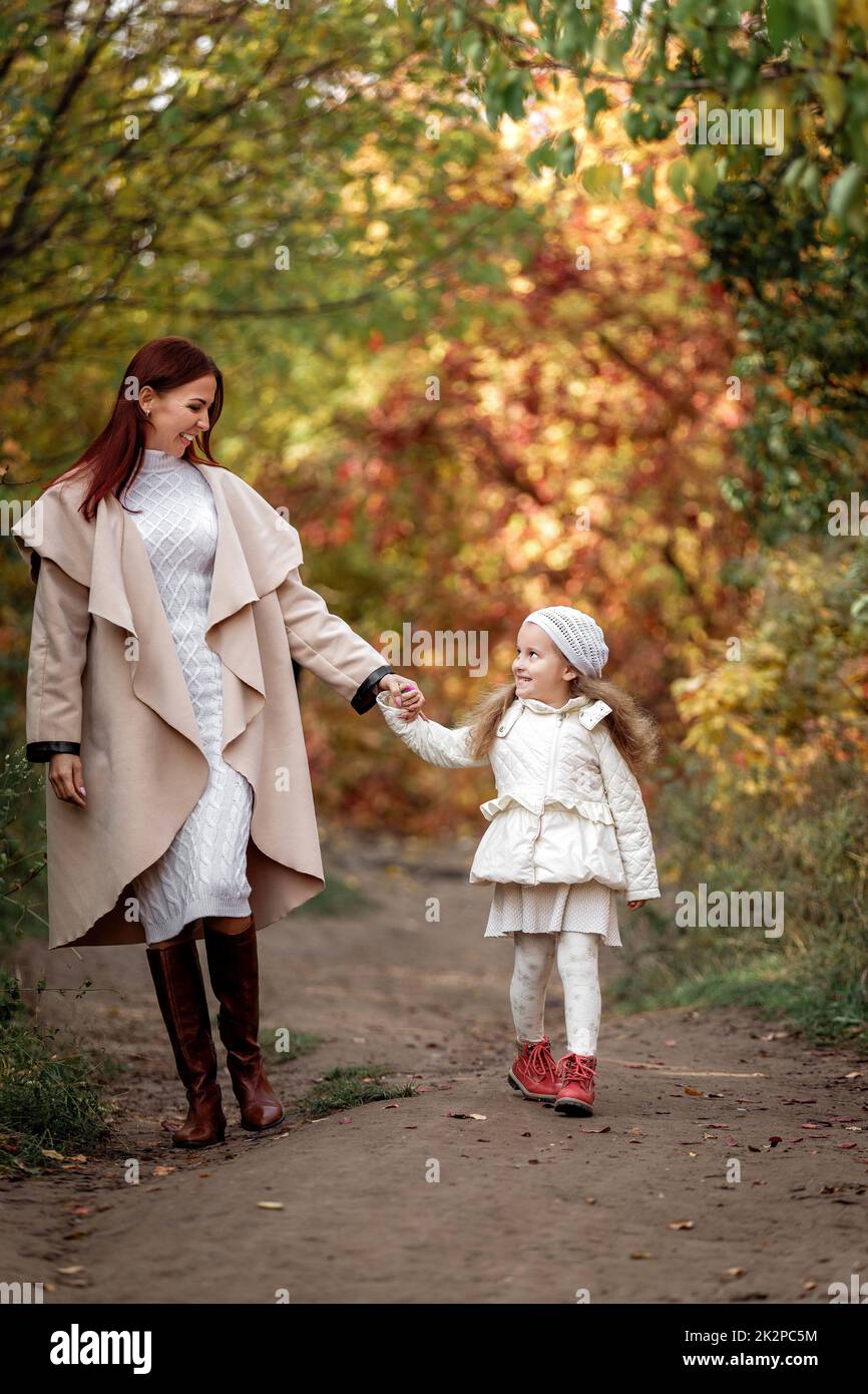 Affascinante madre bella passeggiate con la figlia piccola ragazza Foto Stock