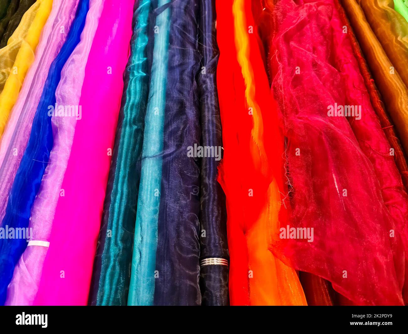 Campioni di stoffe e tessuti in diversi colori trovati in un mercato di tessuti. Foto Stock