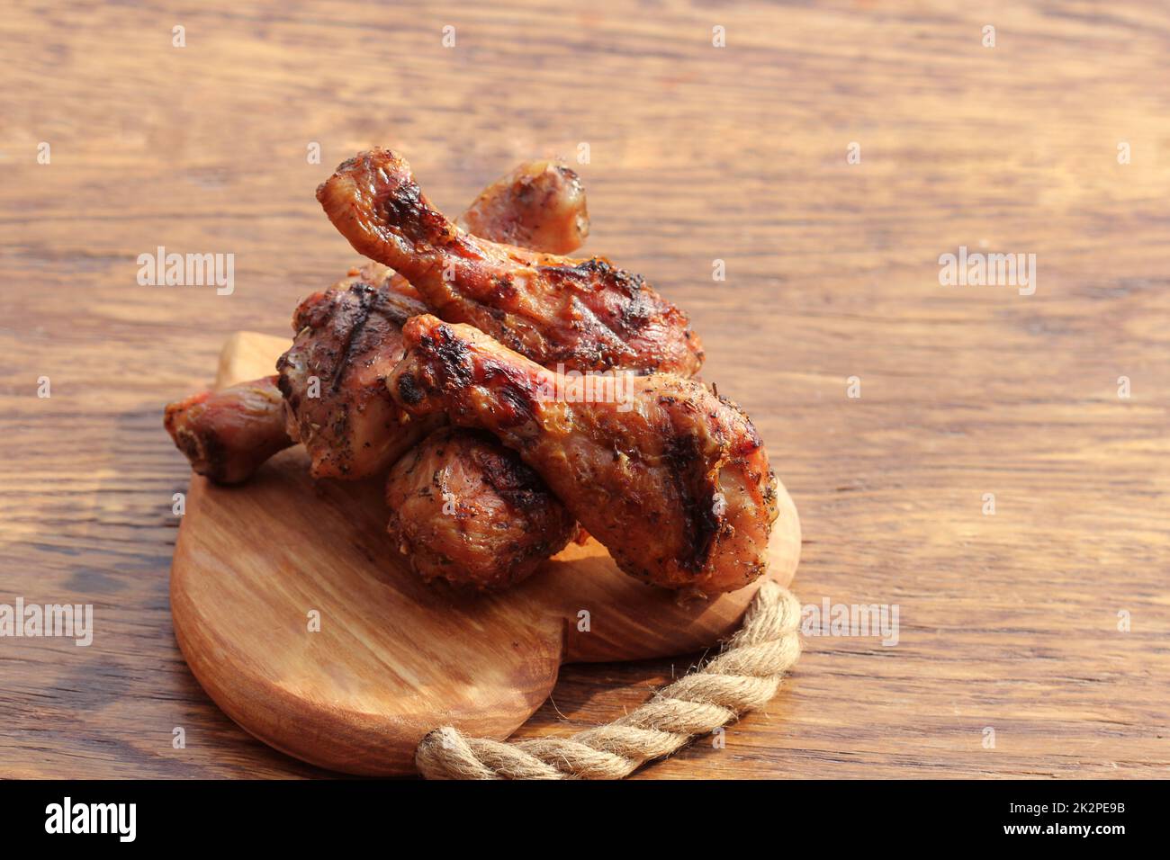 Cosce di pollo alla griglia sul tagliere. Cena rustica sfondo Foto Stock