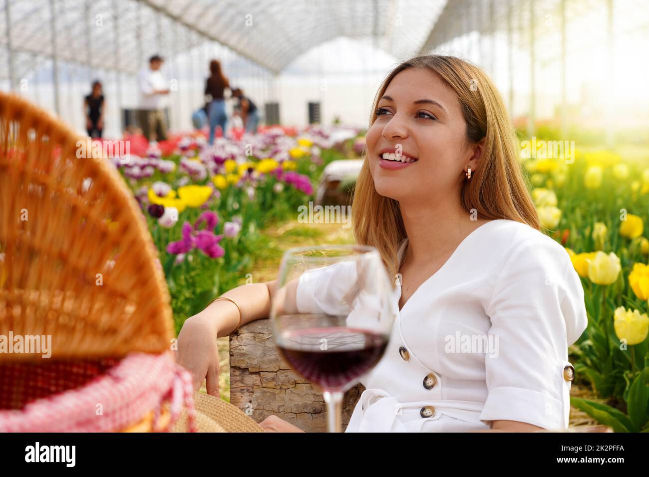 Giovane donna rilassata tra i fiori in pic-nic in primavera. Messa a fuoco selettiva. Foto Stock