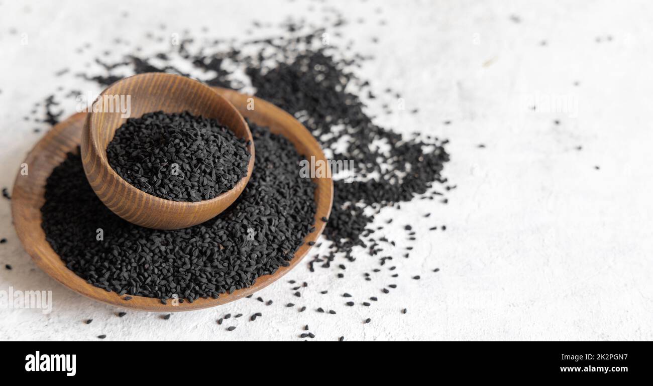 Spezie indiane semi di cumino nero (nigella sativa o kalonji) in ciotole di legno primo piano Foto Stock