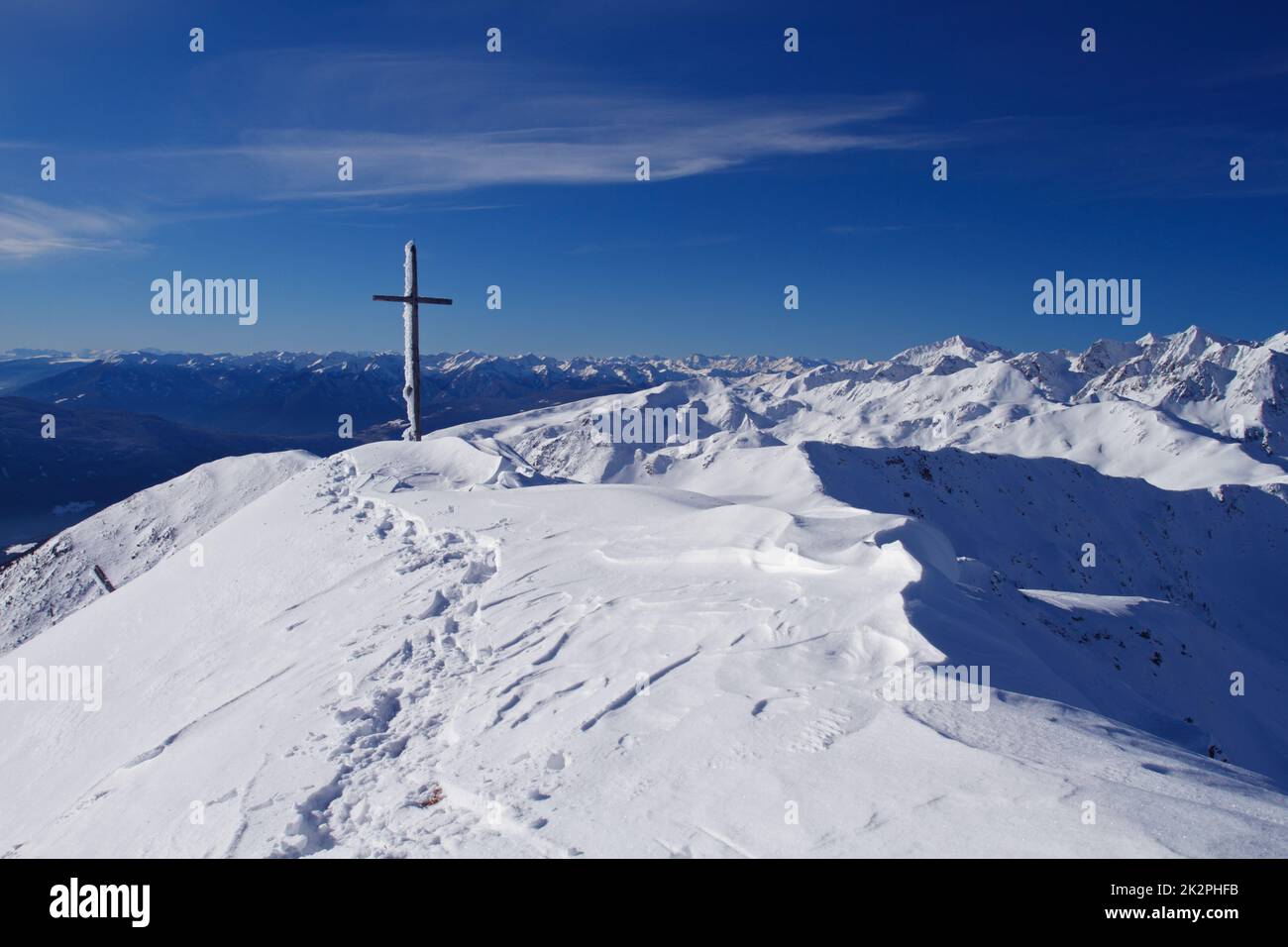 Montagna con croce in cima nella neve Paesaggio nel parco naturale Alto Adige, Alpi, Italia Foto Stock