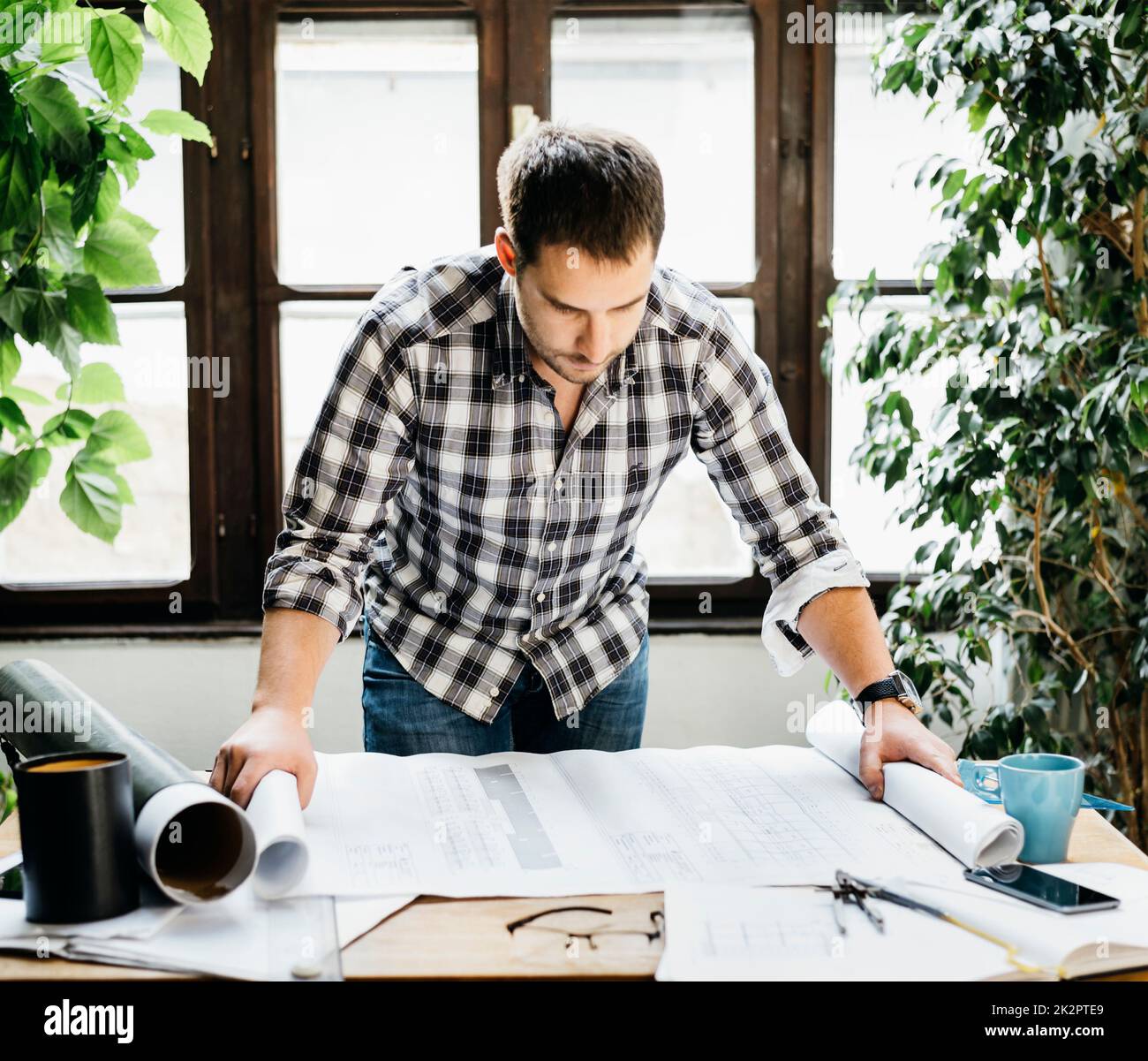Uomo che lavora a un progetto architettonico Foto Stock