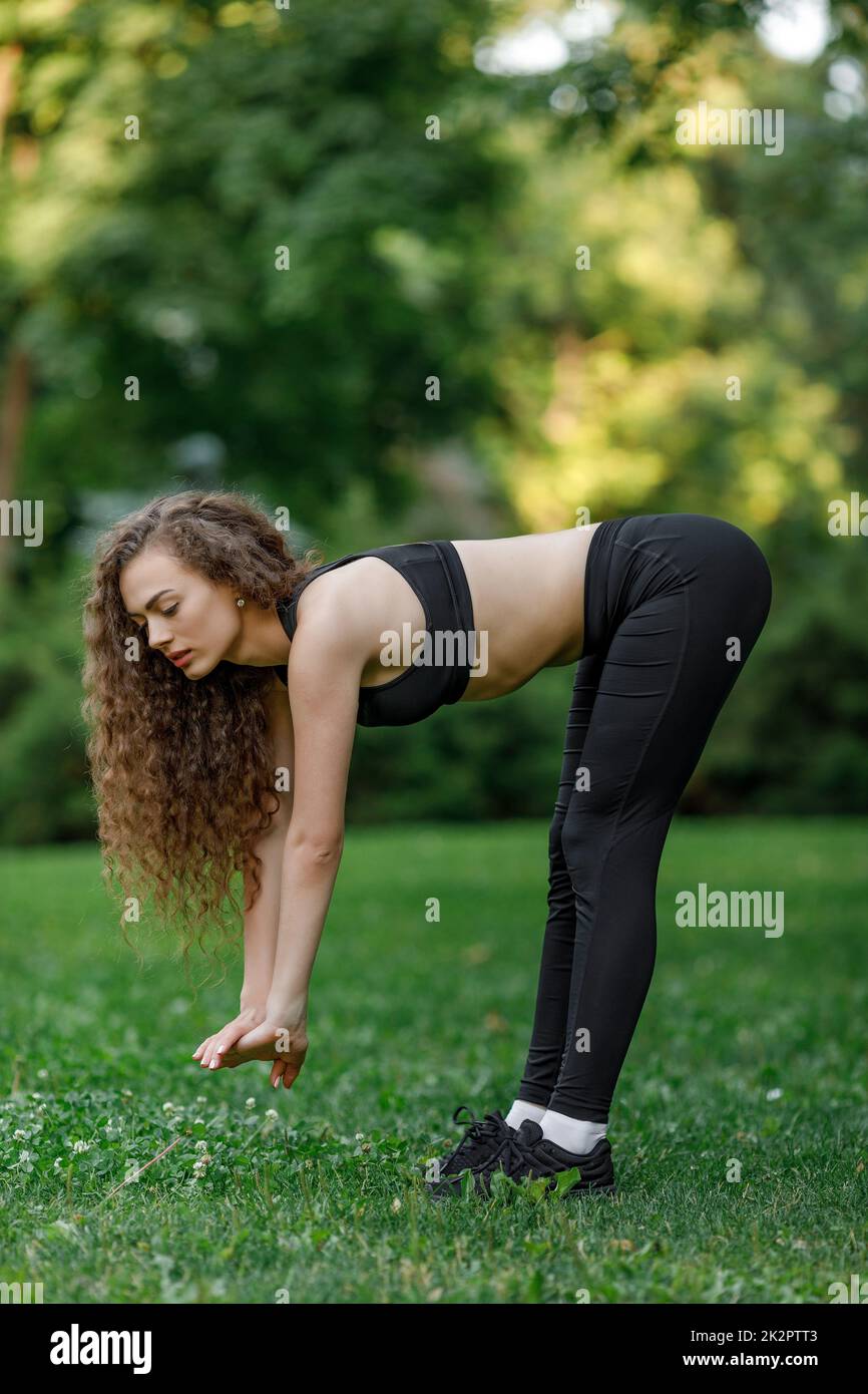 Donna facendo esercizi di stretching prima di eseguire Foto Stock