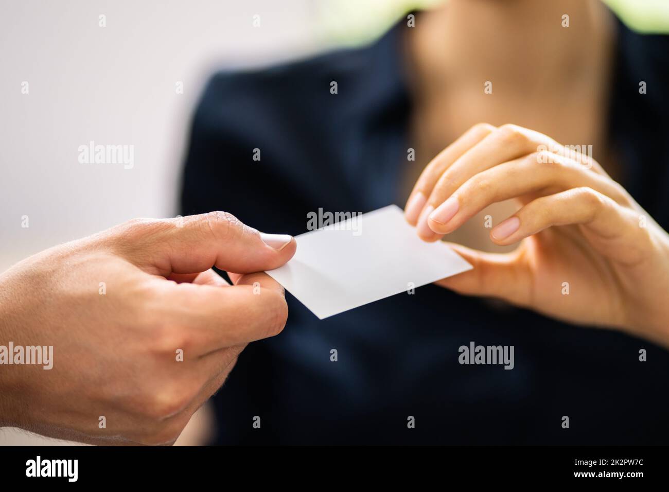 Persona mani dando carta da visita a un'altra persona Foto Stock