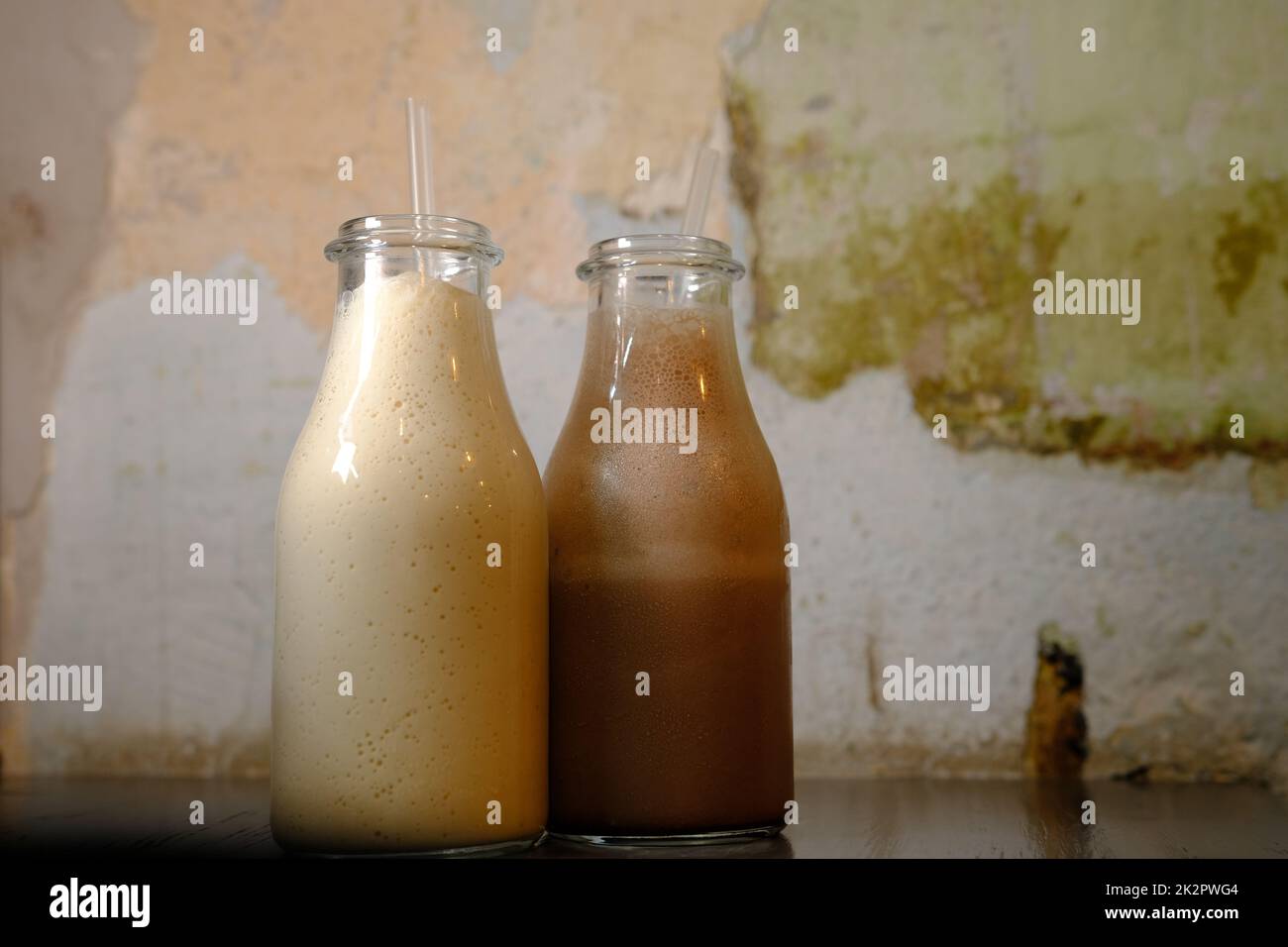 Milkshake latte al cioccolato in bottiglie con cannucce Foto Stock