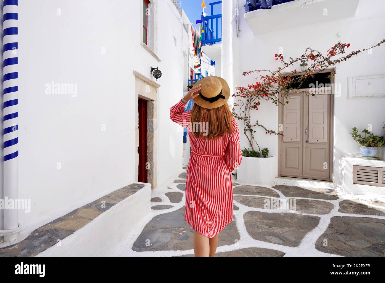 La donna turistica cammina attraverso i vicoli di Mykonos pittoresca città in Grecia Foto Stock