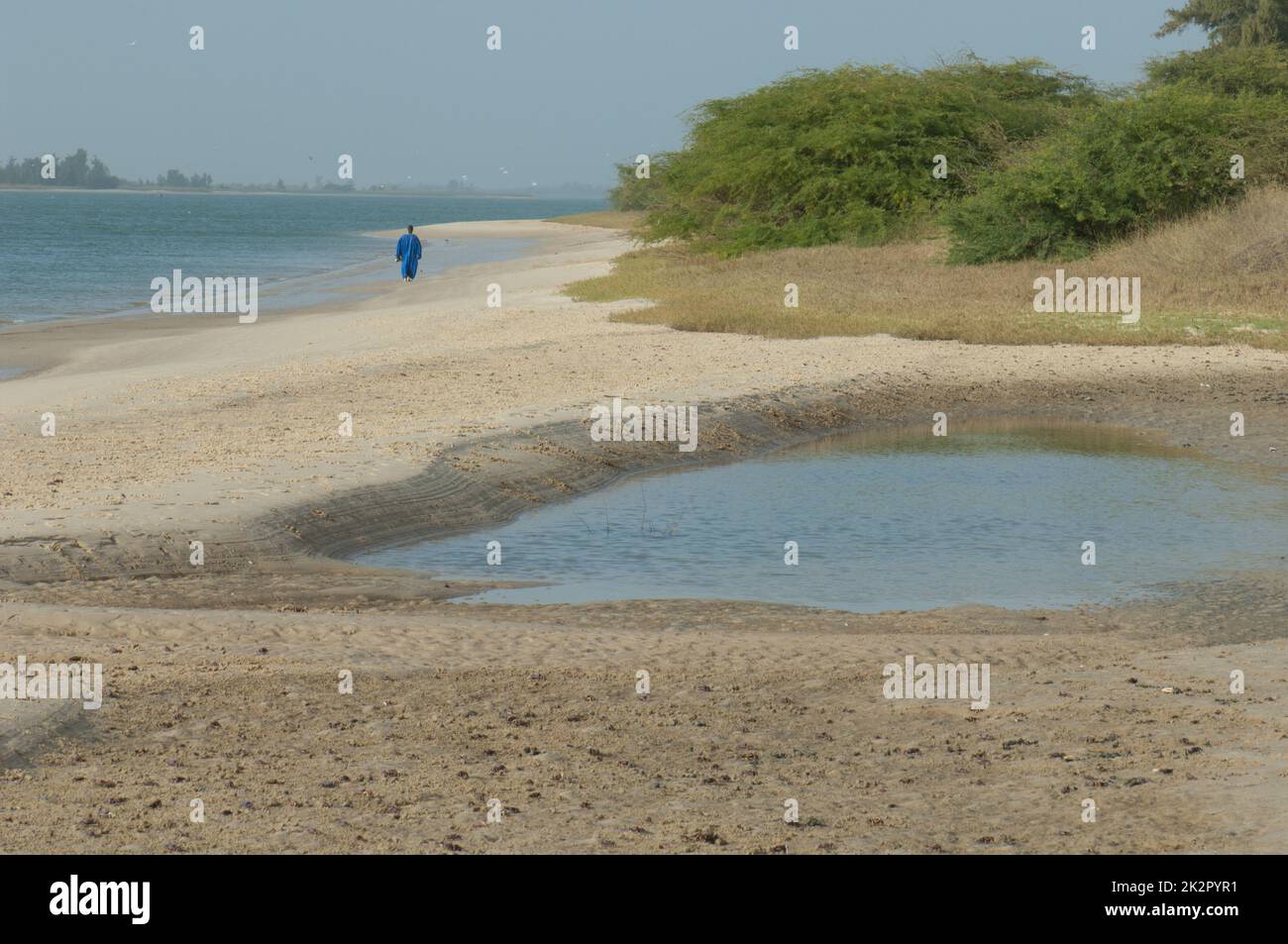 Uomo che cammina lungo la riva di un fiume. Foto Stock
