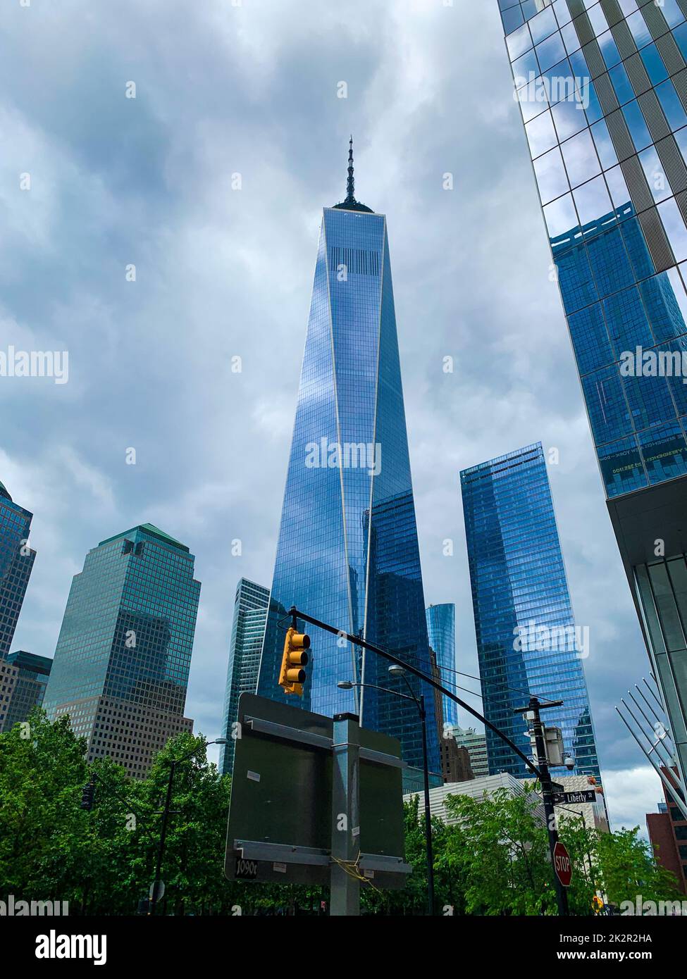 Un basso angolo verticale di edificio futuristico dell'One World Trade Center con un cielo nuvoloso Foto Stock