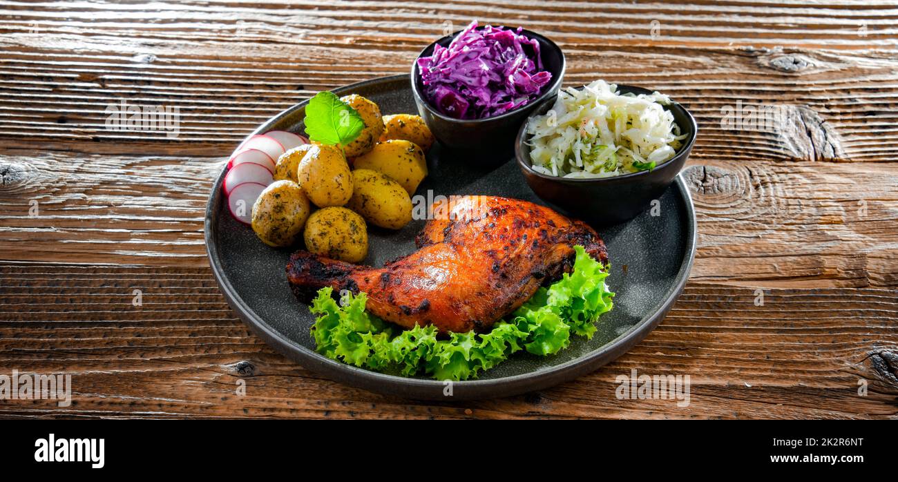 Coscia di pollo al forno con patate e insalate di verdure Foto Stock
