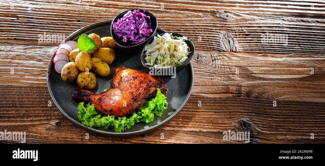 Coscia di pollo al forno con patate e insalate di verdure Foto Stock