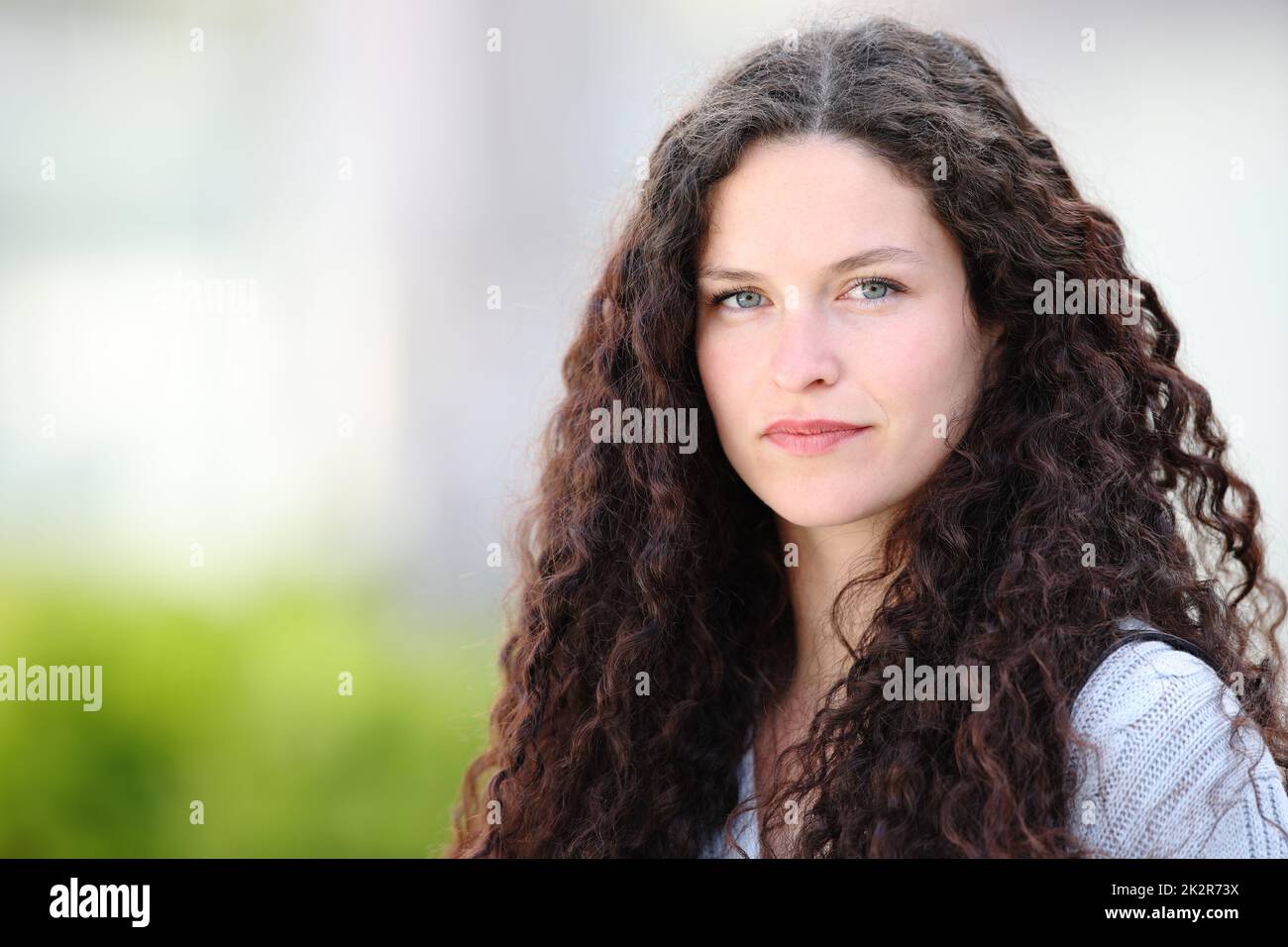 Donna di bellezza con capelli ricci guarda la macchina fotografica Foto Stock