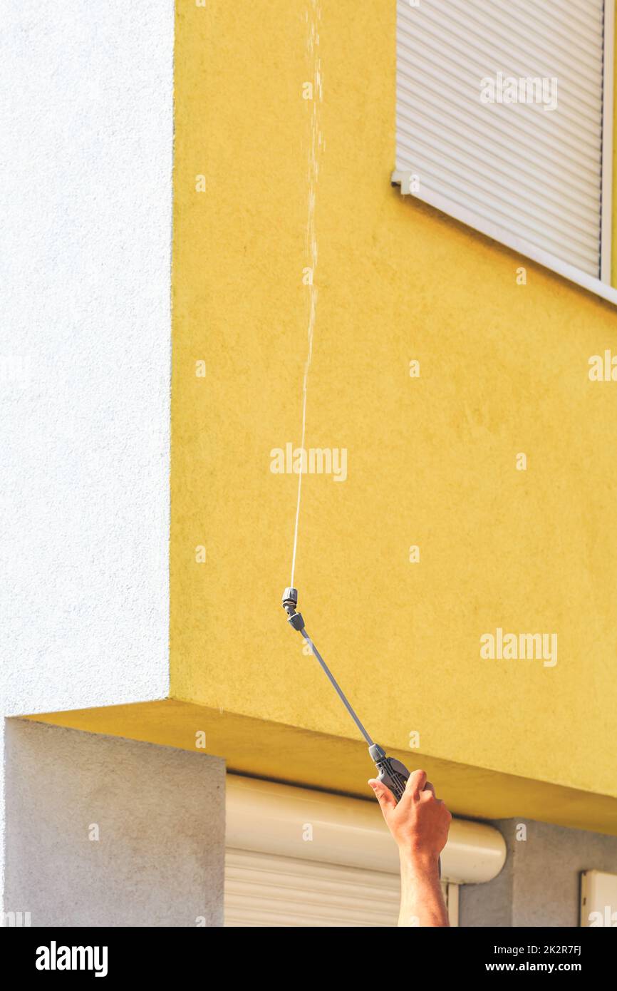 Applicazione di prodotti per la pulizia su facciate sporche con acqua ad alta pressione Foto Stock