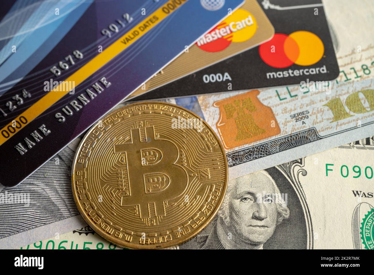 Bangkok, Thailandia, 9 luglio 2021, bitcoin oro con carta di credito su banconote in dollari USA per il cambio elettronico mondiale moneta virtuale, blockchain, criptovaluta Foto Stock