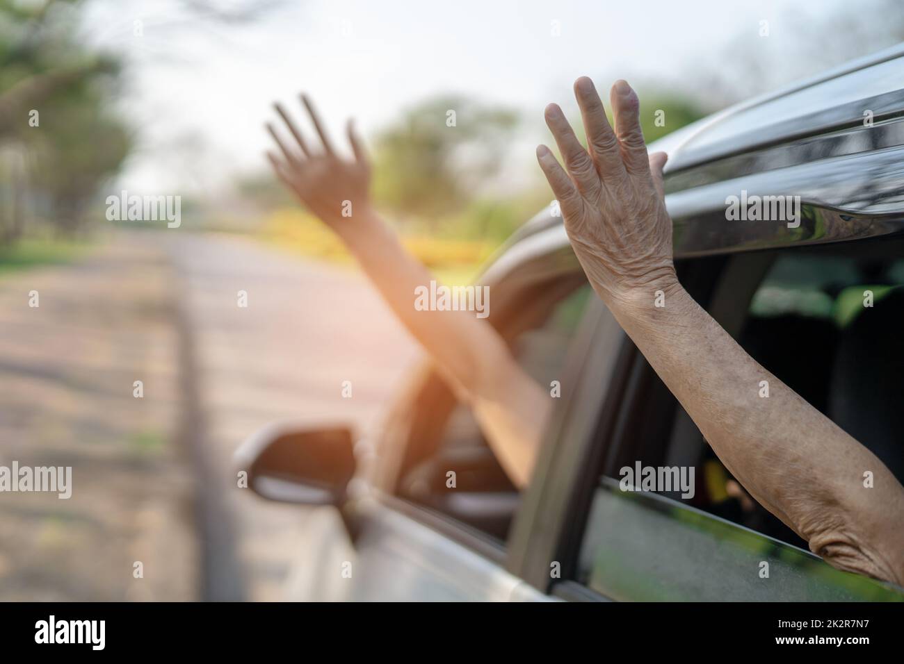 Buon divertimento e libertà in viaggio con la mano madre alzata fuori dalla finestra auto in vacanza estiva Foto Stock