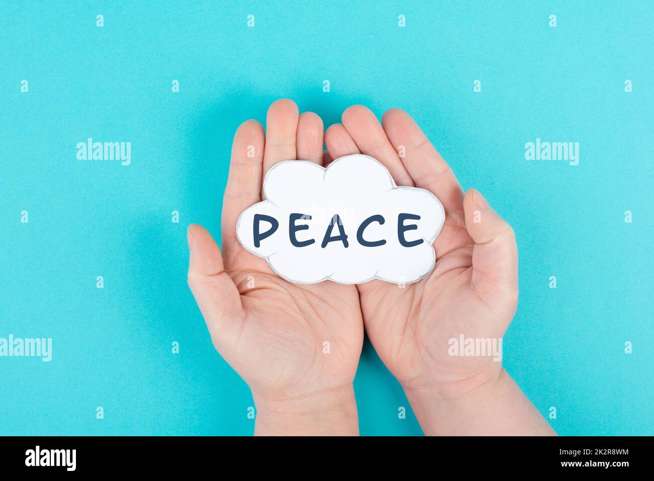 Tenere una nuvola con la parola pace nelle mani, fermare la guerra, sostenere, vivere insieme in pace Foto Stock