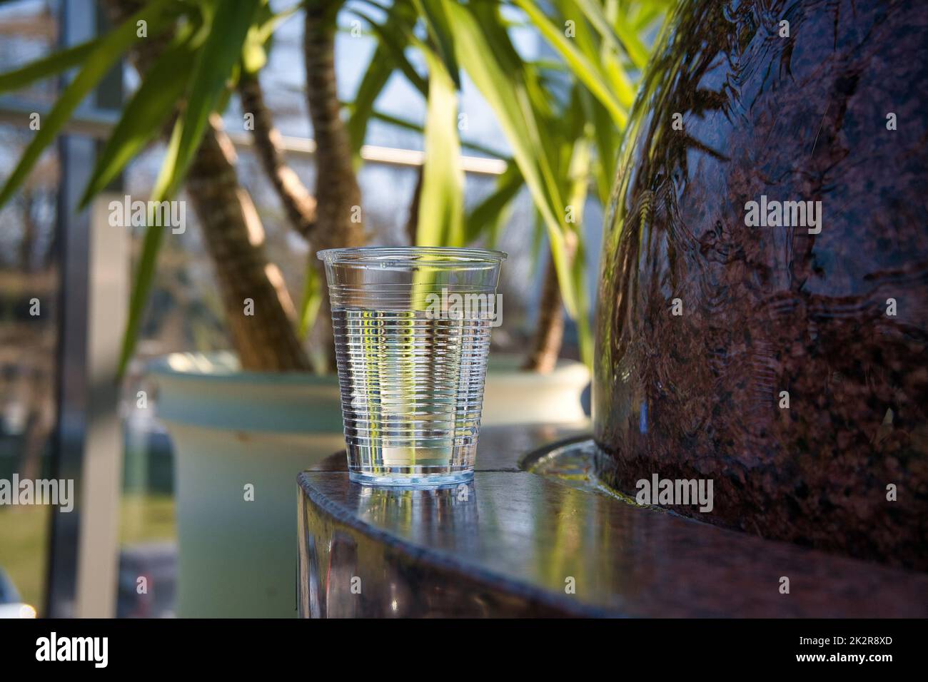 Bicchiere di acqua pulita su una fontana di marmo Foto Stock