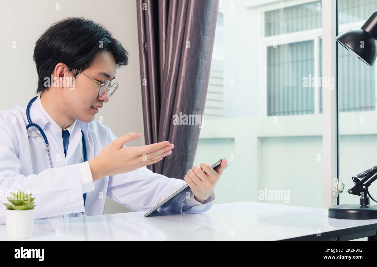 Medico uomo sorriso utilizzare moderno computer tablet digitale intelligente spiegare i sintomi della malattia dei pazienti Foto Stock