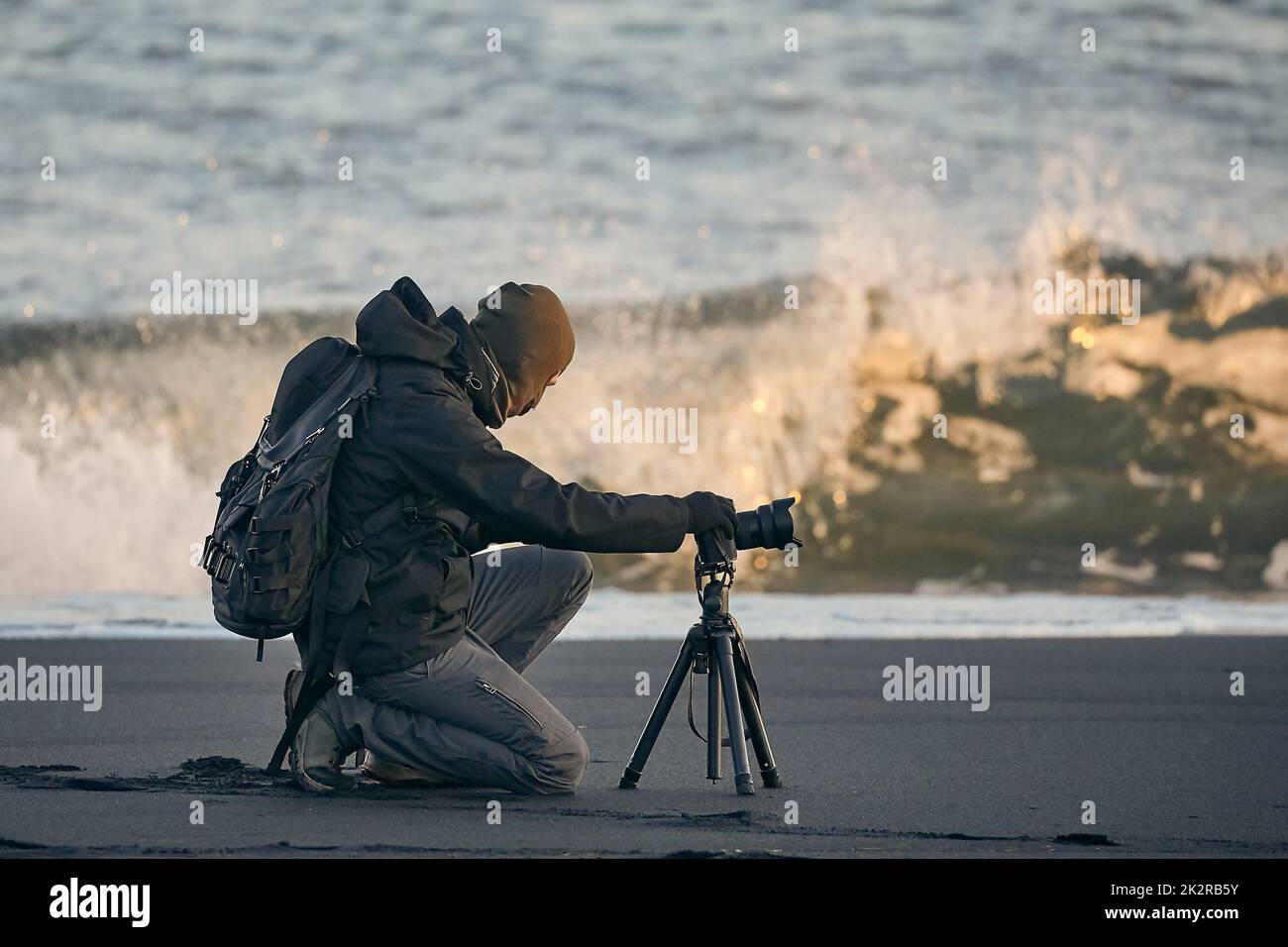 Fotografo con treppiede su una spiaggia islandese Foto Stock
