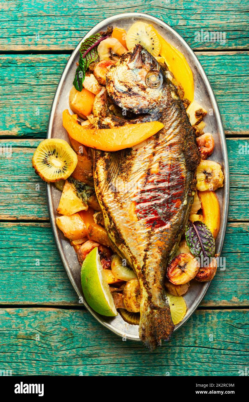 Pesce al forno con ananas, mango e kiwi. Foto Stock