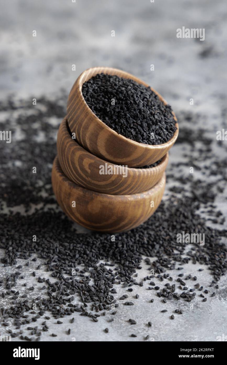 Spezie indiane semi di cumino nero (nigella sativa o kalonji) in ciotole di legno primo piano Foto Stock