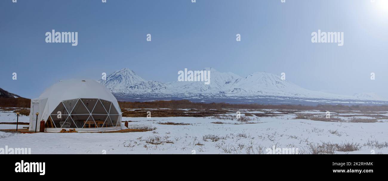 Casa e vulcano glamping, paesaggio rurale, case tenda nella penisola di Kamchatka. Messa a fuoco selettiva. Foto Stock