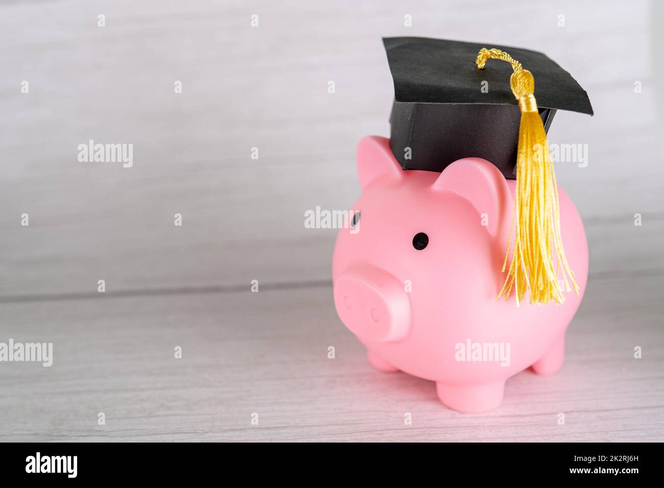 Piggy banca con tappo di graduazione, Business finance formazione risparmio denaro concetto di borsa di studio. Foto Stock