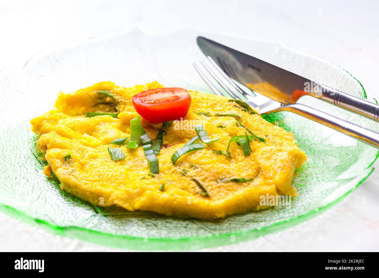 omelette all'uovo con cipolla primaverile e pomodoro Foto Stock